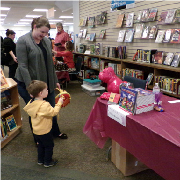 child looking at pink plastic dog